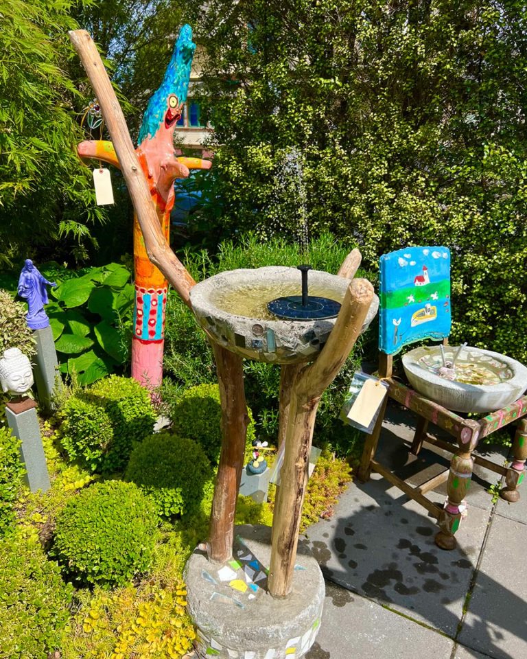 A collection of sculpture, mainly focusing on a fountain made out of driftwood and stone mosaics